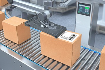 Ein Versandkarton wird in einem F&ouml;rdersystem automatisch mit einem Versandetikett etikettiert.
