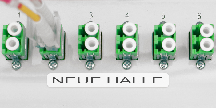 Etikett mit der Beschriftung „NEUE HALLE“ kennzeichnet Anschlüsse in einem Server- oder Verteilerschrank übersichtlich.