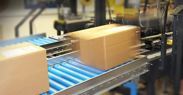 Versandkartons bewegen sich auf einem Förderband für den schnellen europaweiten Versand.