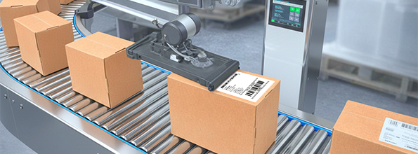 Automatisierte Förderanlage bringt Versandkartons mit Barcodes an, die von einem Applikator aufgebracht werden – zeigt die Automatisierung in der Logistik durch Etiketten.
